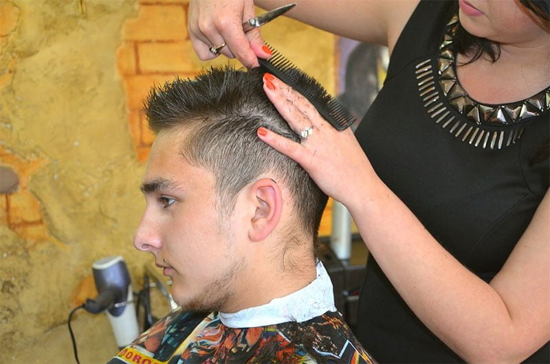 Women cutting men hair